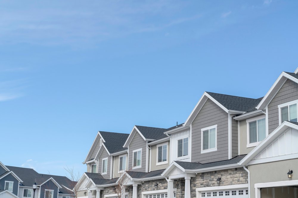 Homes,With,Gable,Roofs,And,Gray,Exterior,Walls,Against,Blue